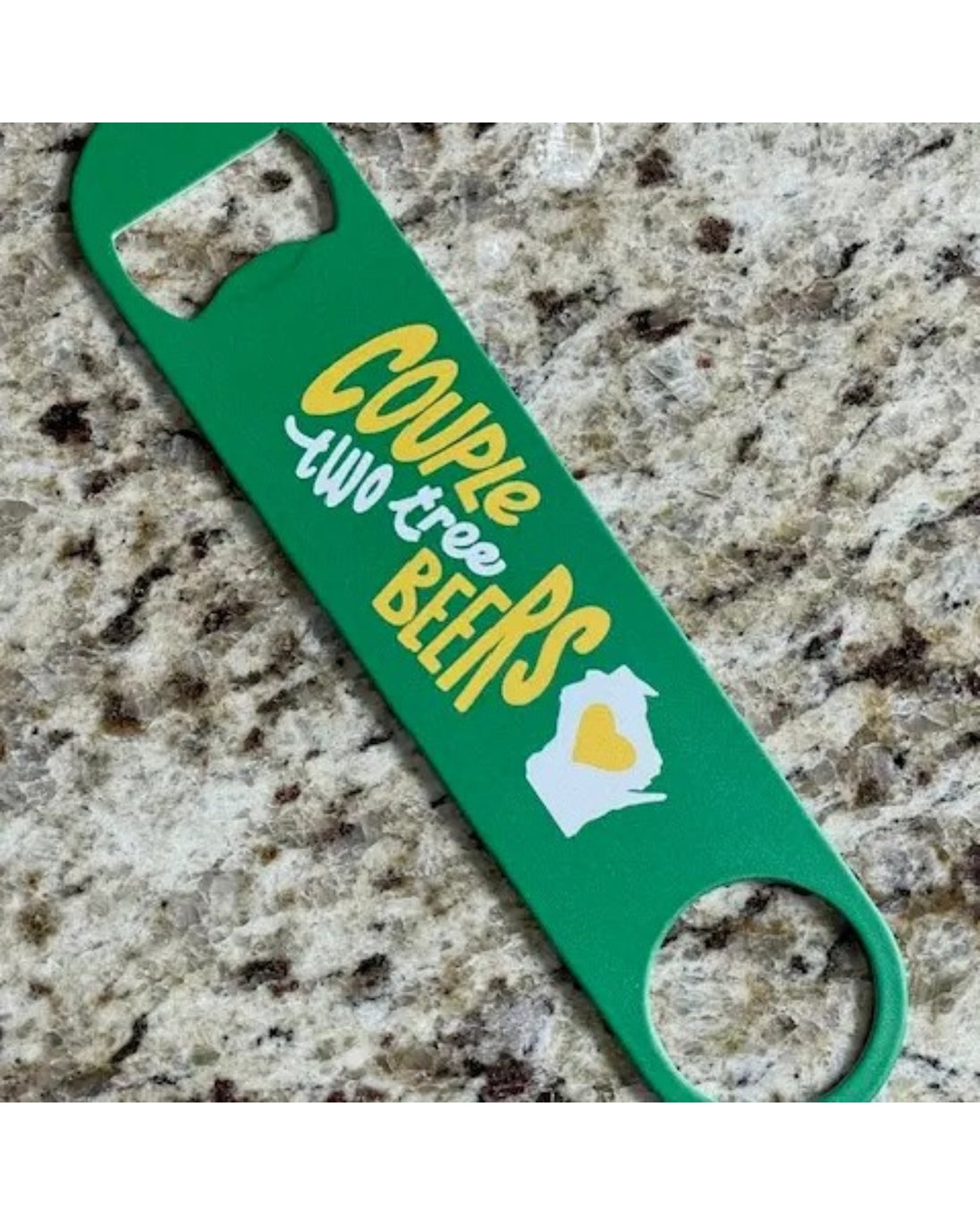 Green bottle opener with humorous text and design on a speckled countertop
