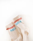 Cream-colored socks with 'MILK' text on a white background